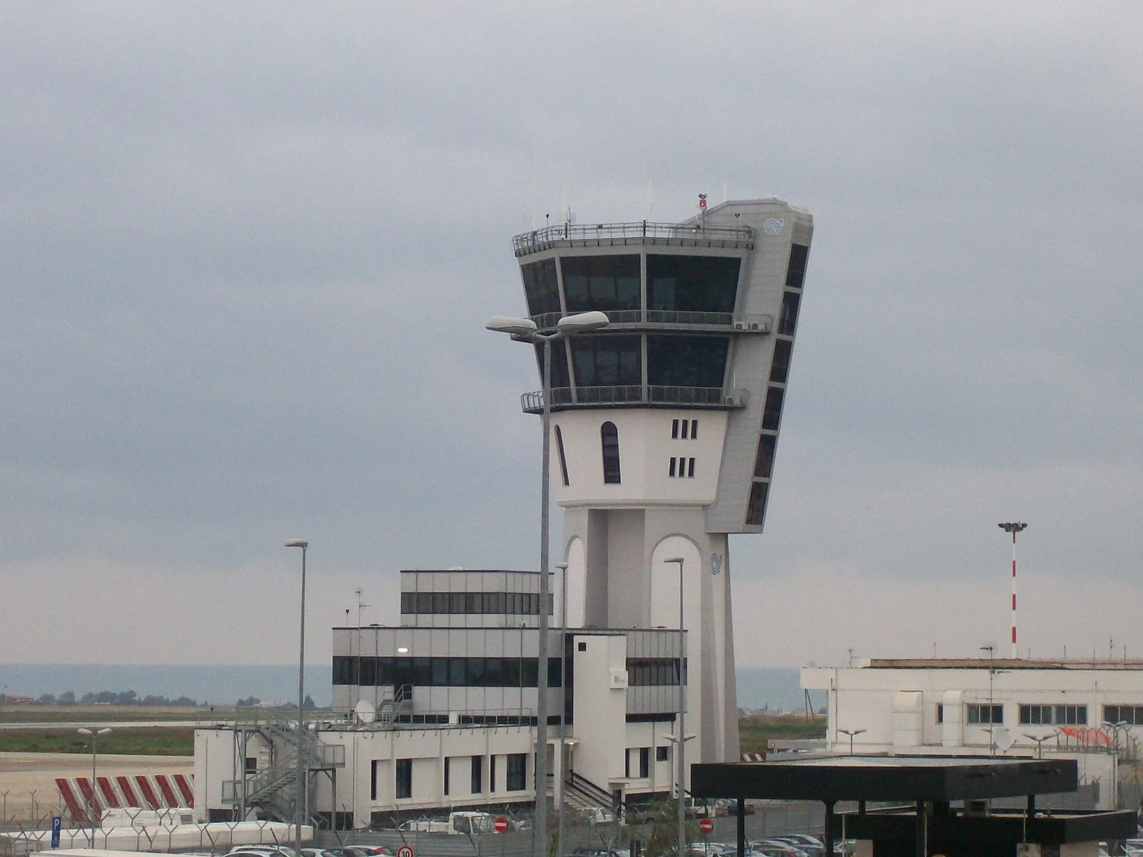 La torre di controllo dell'Aeroporto di Bari con gli edifici di servizio e il cielo nuvoloso sullo sfondo